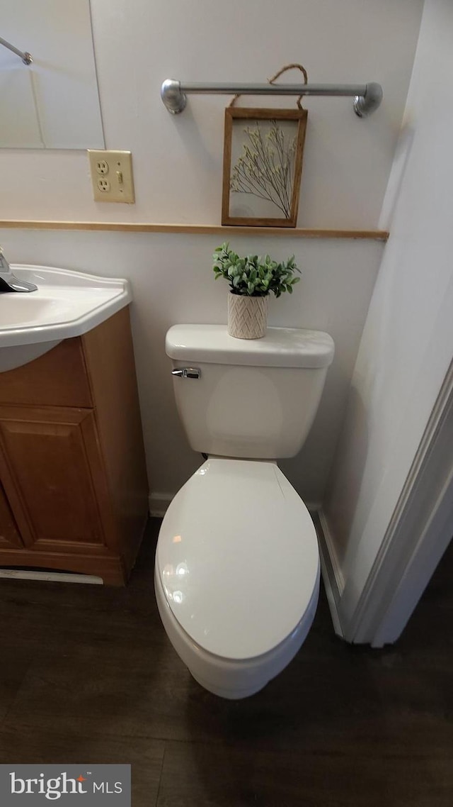 bathroom with toilet, large vanity, and hardwood / wood-style floors