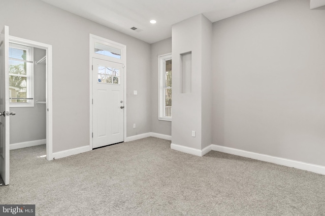 foyer entrance featuring light colored carpet