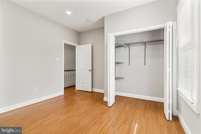 unfurnished bedroom featuring a closet and light hardwood / wood-style flooring