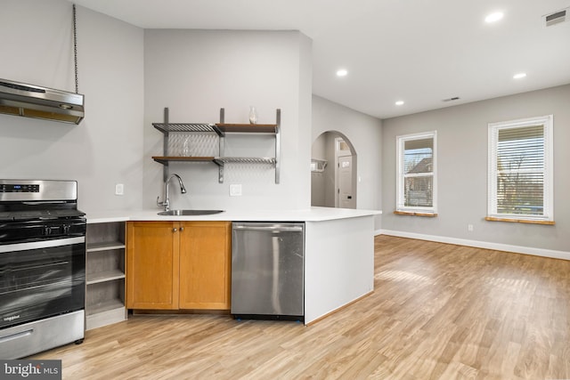 kitchen with stainless steel appliances, light wood-type flooring, and sink