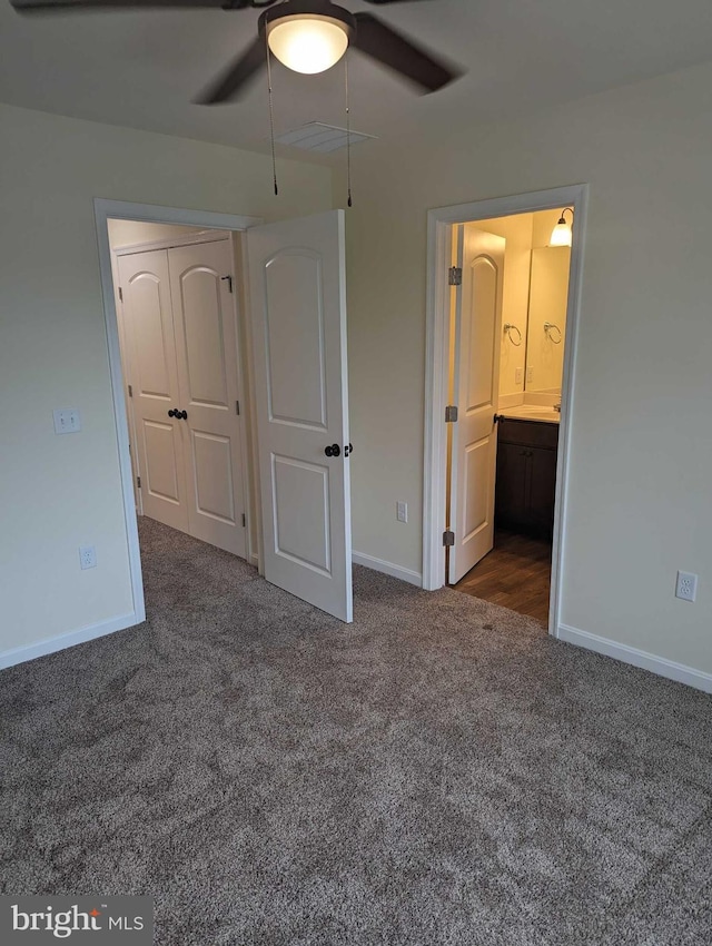 unfurnished bedroom with ceiling fan and dark carpet