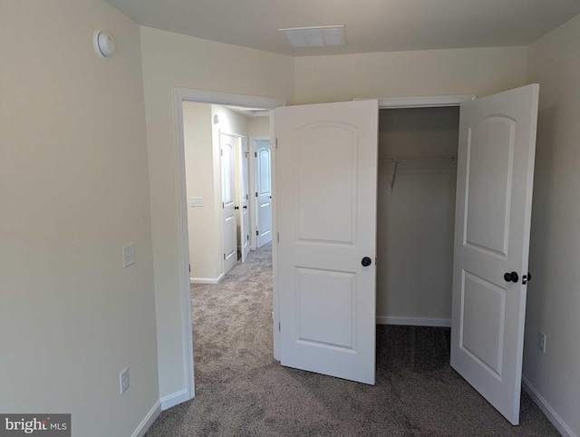 unfurnished bedroom with a closet and carpet floors