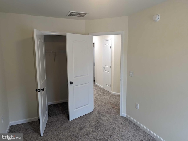 unfurnished bedroom with carpet flooring and a closet