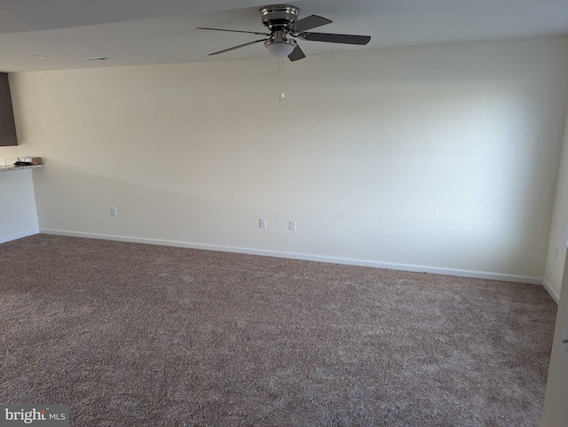 empty room featuring ceiling fan and carpet