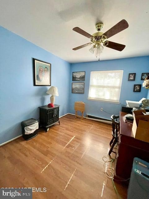 office with baseboard heating, ceiling fan, and light wood-type flooring