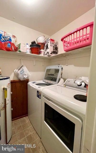 laundry room featuring washer hookup, water heater, light tile flooring, and washing machine and dryer