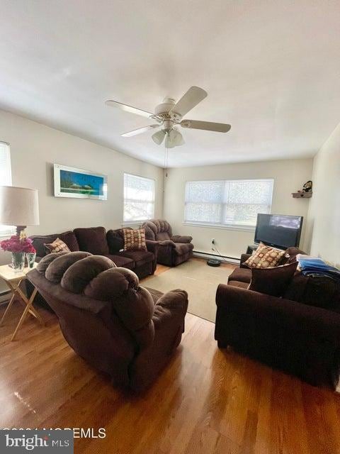 living room with ceiling fan, a baseboard radiator, and hardwood / wood-style floors