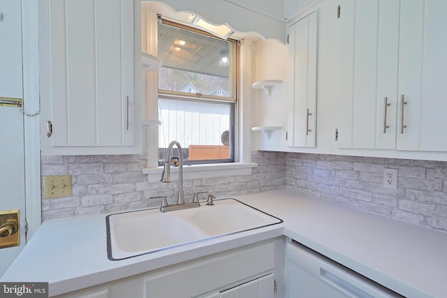 kitchen featuring white cabinets, white dishwasher, tasteful backsplash, and sink