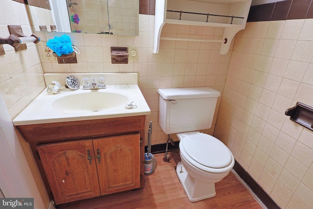 bathroom with tile walls, toilet, hardwood / wood-style floors, and oversized vanity