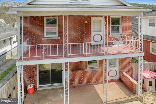 back of property with a balcony and a patio