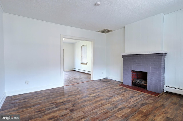 unfurnished living room with a textured ceiling, a brick fireplace, dark hardwood / wood-style floors, and a baseboard heating unit