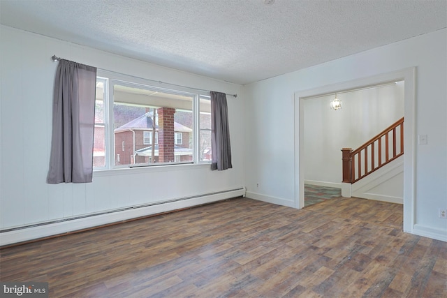 empty room with dark hardwood / wood-style flooring, a baseboard radiator, and a textured ceiling