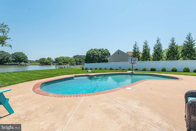 view of swimming pool featuring a yard, a water view, and a patio