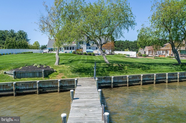 dock area with a yard and a water view