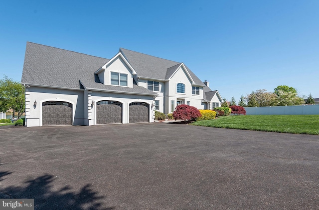 view of front of property with a garage and a front lawn