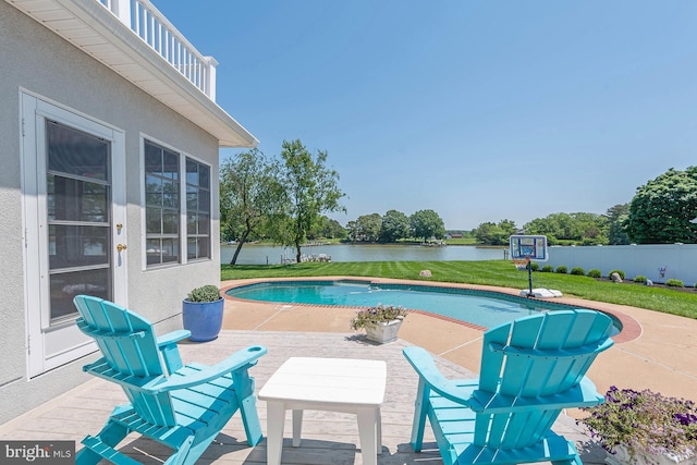 view of swimming pool featuring a patio area, a yard, and a water view