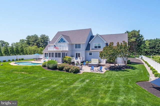 back of house featuring a balcony, a yard, a fenced in pool, and a patio area