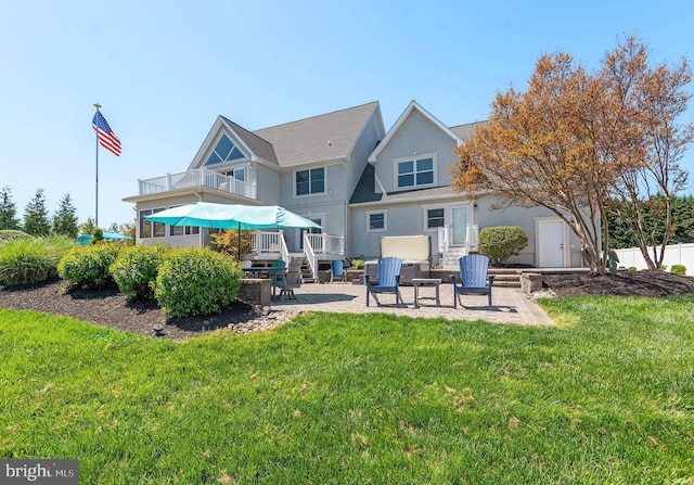 back of property featuring a lawn, a patio area, an outdoor living space, and a balcony