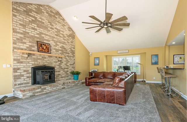 living room with ceiling fan, dark hardwood / wood-style flooring, a wood stove, and lofted ceiling