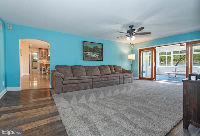 living room featuring ceiling fan and dark wood-type flooring