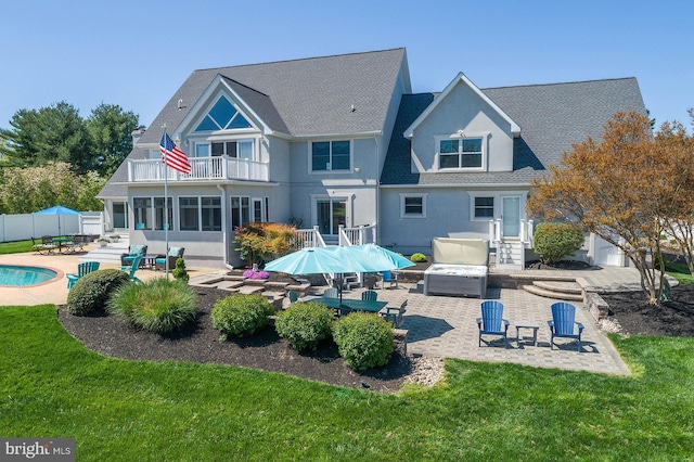 back of house featuring a lawn, a patio area, an outdoor living space, and a balcony