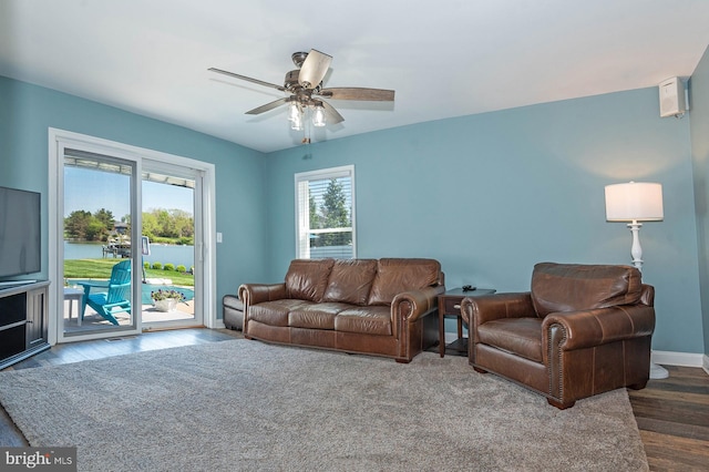 living room with ceiling fan and dark wood-type flooring