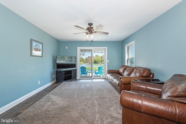 living room featuring ceiling fan and dark hardwood / wood-style floors