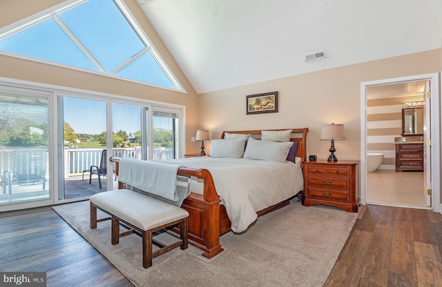 bedroom with wood-type flooring, access to outside, high vaulted ceiling, and ensuite bath