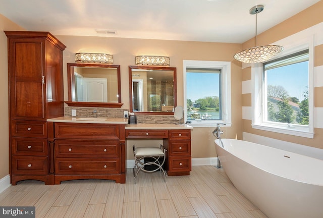 bathroom featuring backsplash, a tub, and vanity