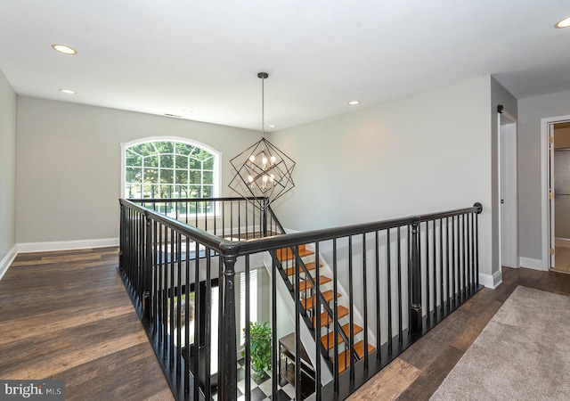 corridor featuring dark hardwood / wood-style flooring and an inviting chandelier