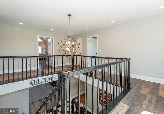 hall featuring an inviting chandelier and dark wood-type flooring