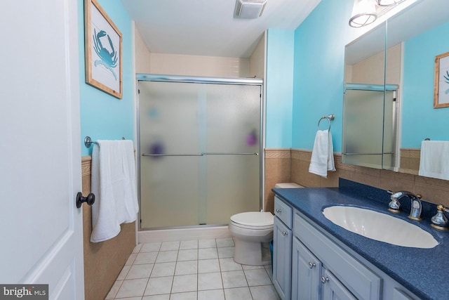 bathroom with tile patterned floors, vanity, toilet, and walk in shower