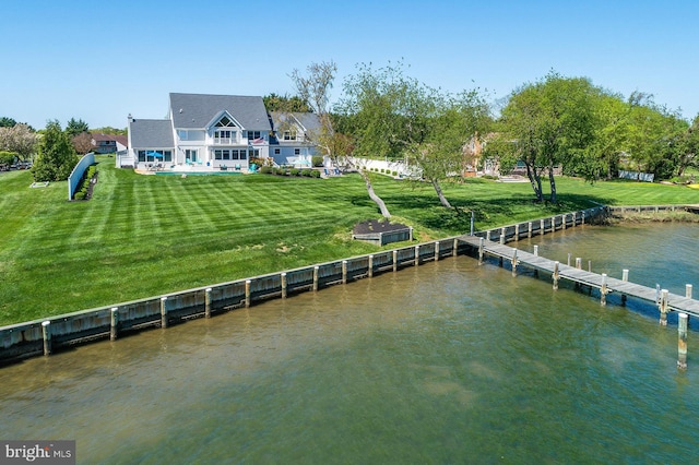 rear view of property featuring a lawn and a water view