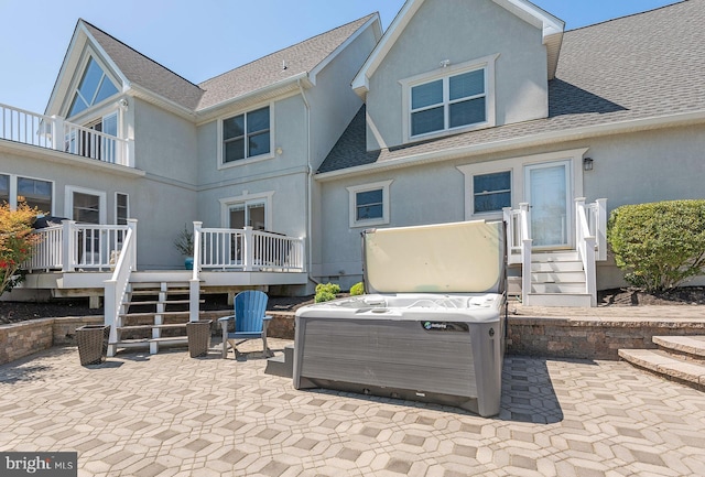 rear view of property featuring a patio, a hot tub, and a deck