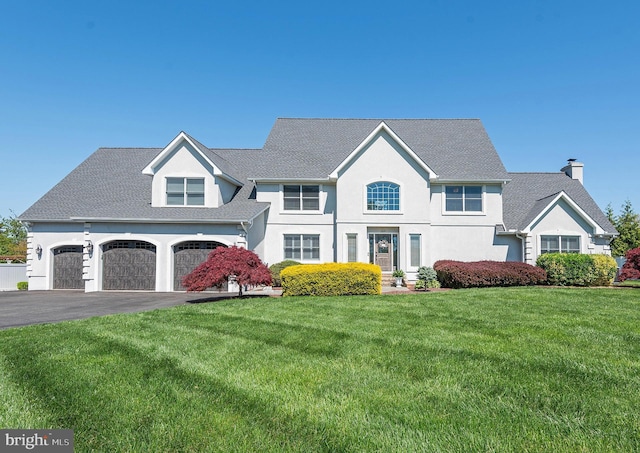 view of front of property featuring a garage and a front lawn