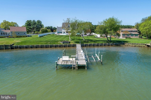 view of dock with a yard and a water view