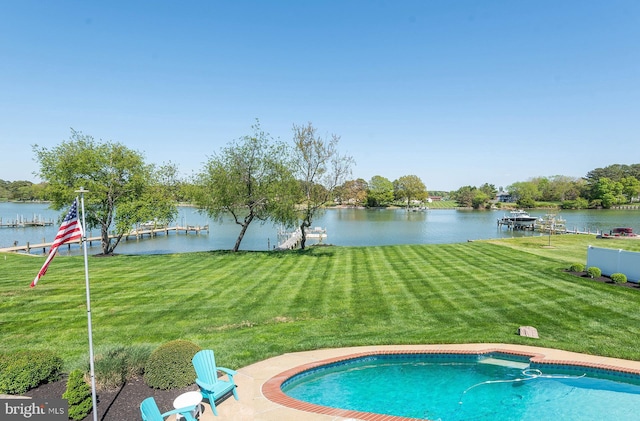 view of swimming pool featuring a yard and a water view