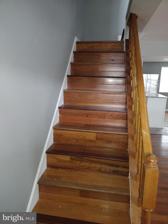 staircase with dark wood-type flooring