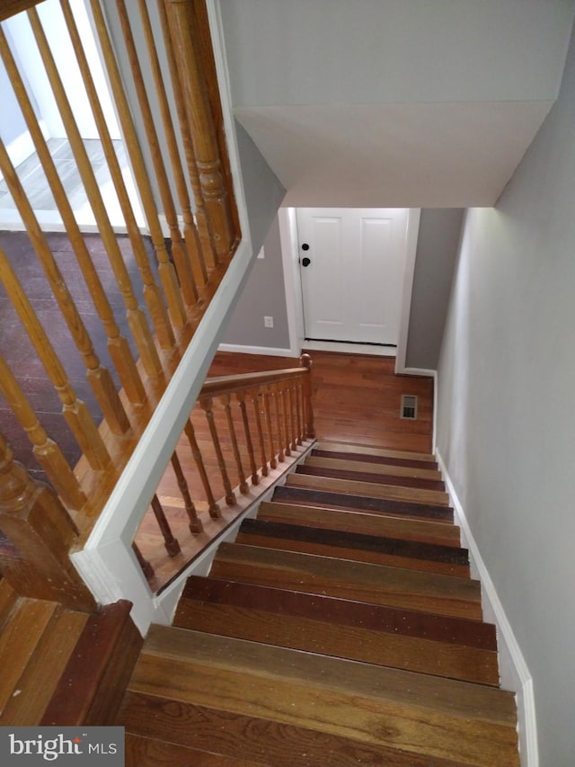 stairs with dark hardwood / wood-style flooring