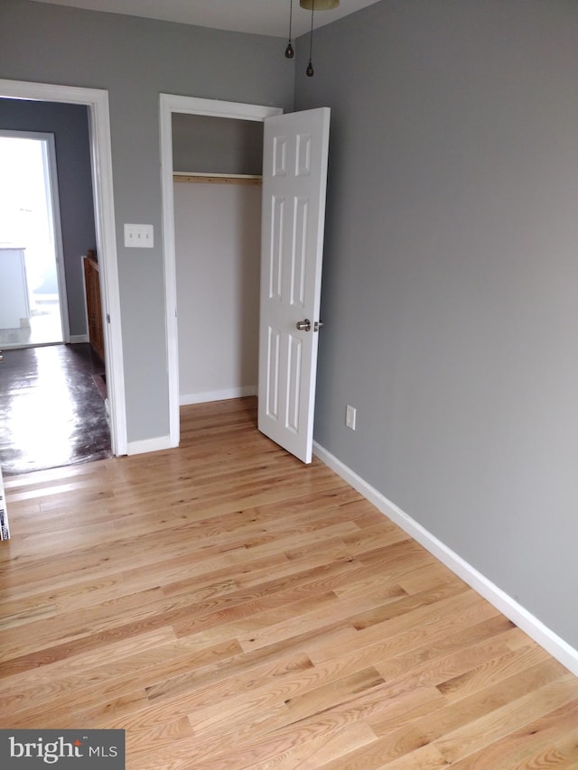 unfurnished bedroom featuring a closet and light hardwood / wood-style flooring