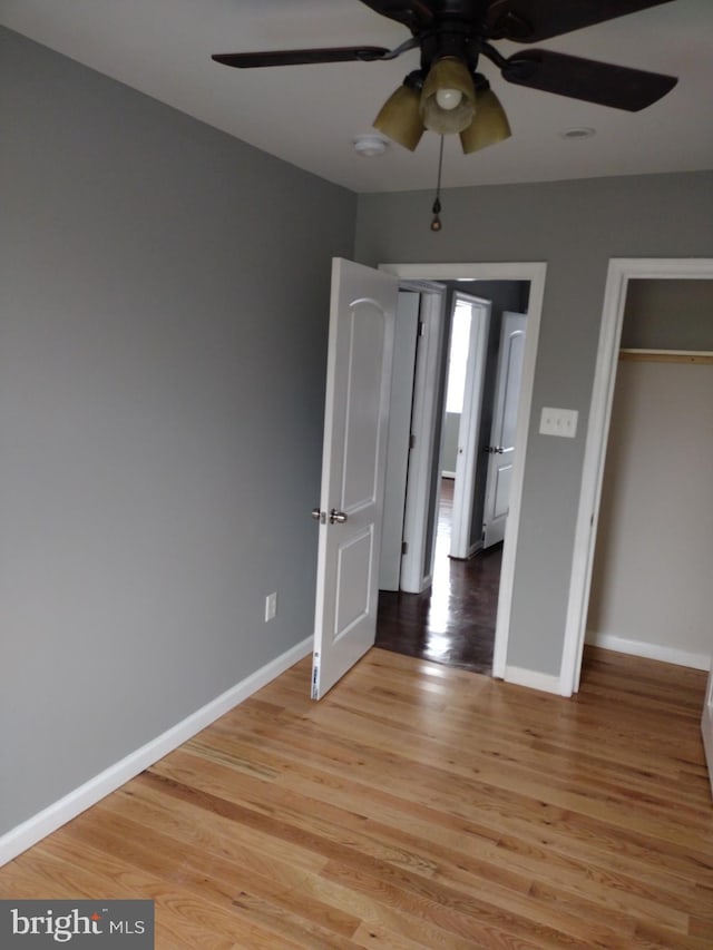 unfurnished bedroom featuring a closet, ceiling fan, and light wood-type flooring