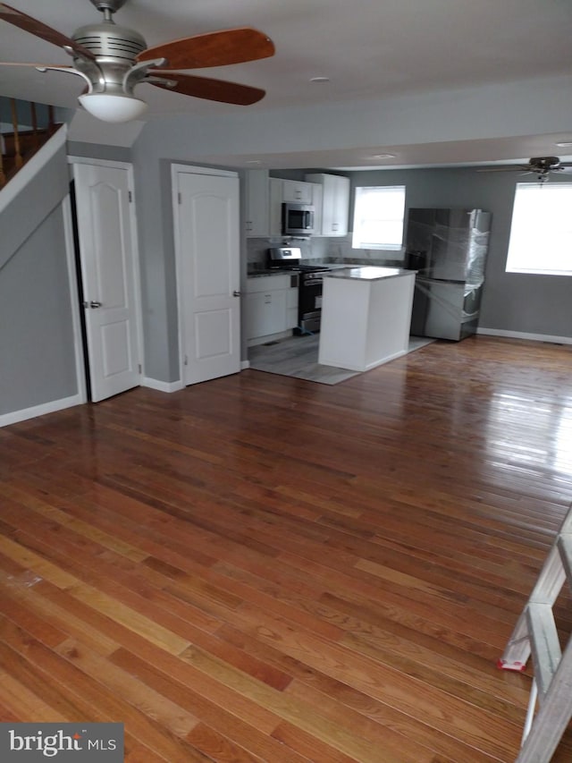 unfurnished living room featuring ceiling fan and light wood-type flooring