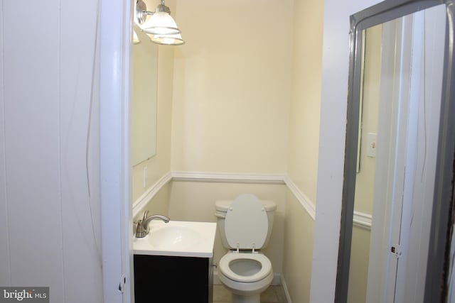 bathroom featuring toilet, tile floors, and vanity