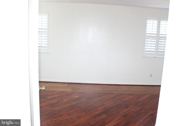 unfurnished room featuring dark wood-type flooring