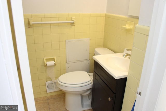 bathroom featuring toilet, tile flooring, vanity, and tile walls