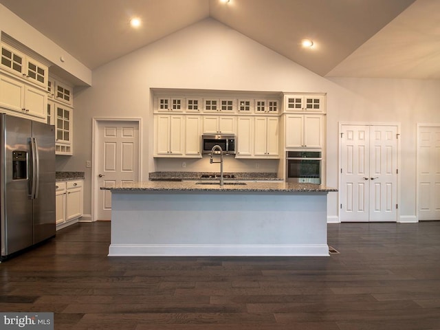 kitchen featuring high vaulted ceiling, stainless steel appliances, a center island with sink, dark wood-type flooring, and white cabinetry