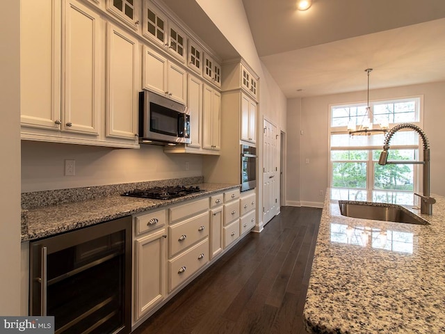 kitchen featuring wine cooler, appliances with stainless steel finishes, sink, and light stone counters