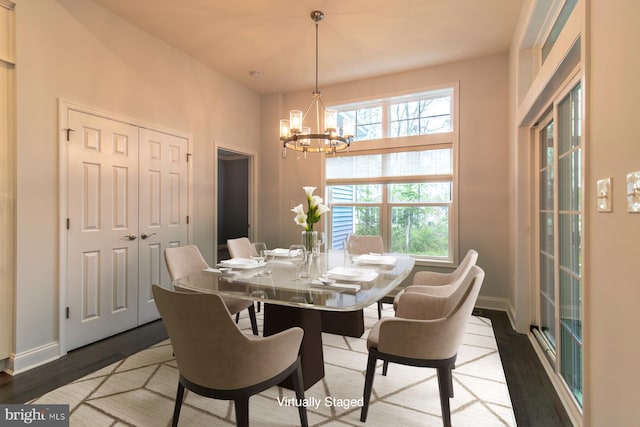 dining area with wood-type flooring and a chandelier