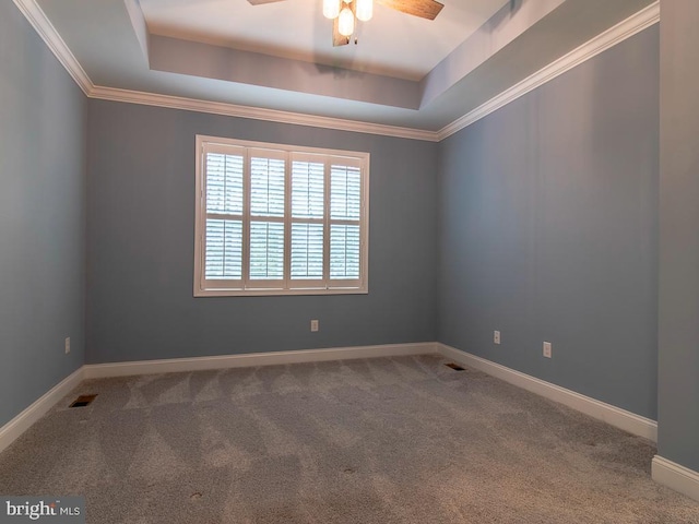 unfurnished room with dark colored carpet, ceiling fan, and a tray ceiling