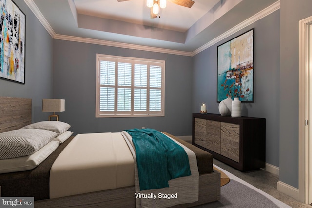 carpeted bedroom featuring ornamental molding, ceiling fan, and a tray ceiling